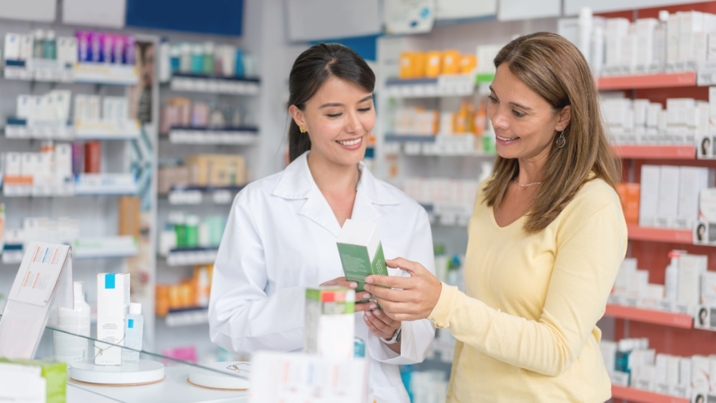 Pharmacist helping a woman choose medication at the pharmacy counter.